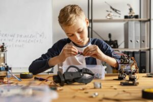 Importanti investimenti sono contemplati nel Piano Nazionale di Ripresa e Resilienza per il rinnovamento delle aule didattiche per la scuola 40. Quali sono, però, le metodologie più appropriate nel contesto della scuola 4.0? Nella foto un bambino che prova a elaborare un modello di robot.