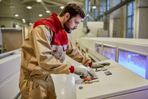 La comprensione del codice G è fondamentale per la programmazione CNC delle macchine utensili. Nella foto, un ingegnere che programma le funzioni di un macchinario in fabbrica.