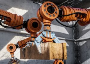 Oggi l'automazione dei processi industriale è molto più forte in virtù di installazioni tecnologiche come le isole robotizzate con cobot. Nella foto, braccia robotiche che sollevano pesi.