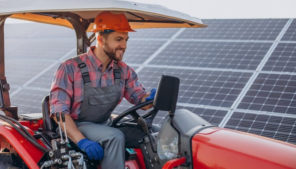 Mekhan offre diversi corsi per formarsi come tecnici di veicoli agricoli e commerciali, basati tutti sul modello learning by doing. Nella foto, un uomo che guida un veicolo agricolo, con pannelli solari sullo sfondo.