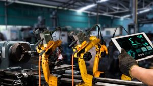 L'automazione industriale di oggi permette di ottimizzare i cicli di produzione e di monitorare lo stato delle macchine in un'ottica di manutenzione predittiva. Nella foto, braccia robotiche che lavorano in un contesto industriale.