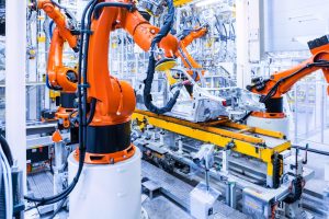 Nella foto, braccia robotiche che lavorano in una smart factory.